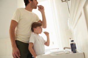 father son brushing teeth